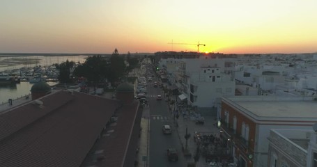 Aerial sunset cityscape of Olhao downtown, view of ancient neighbourhoods traditional cubist architecture and landmark market. Algarve, Portugal.