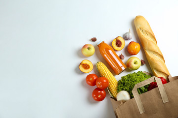 Bunch of mixed organic fruits, vegetables & greens, gourmet pile in full eco friendly shopping bag to reduce ecological footprint. Zero waste concept. White table background, copy space, close up.