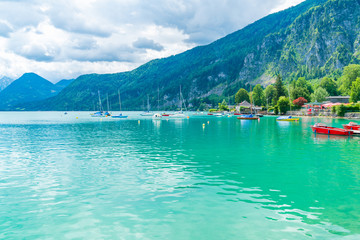 ST. GILGEN, AUSTRIA - JULY 12, 2019: Boats on Wolfgangsee lake in Sankt Gilgen village in a well-known travel destination of Salzkammergut resort region in Austria