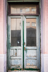Obraz na płótnie Canvas wooden door with glass. White front door in Old abandoned facade. weathered double wooden door