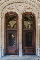 Fototapeta na wymiar Wooden brown Front Door of a Luxurious house. Doors with glass and forged window grille