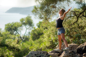 Naklejka premium Mid aged happy woman practising yoga in forest.