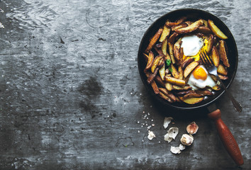 Fried potatoes and eggs in a pan close-up. horizontal