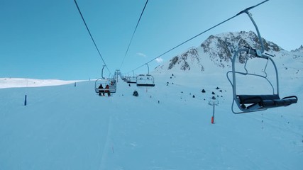 Riding ski chair lift on sunny winter day