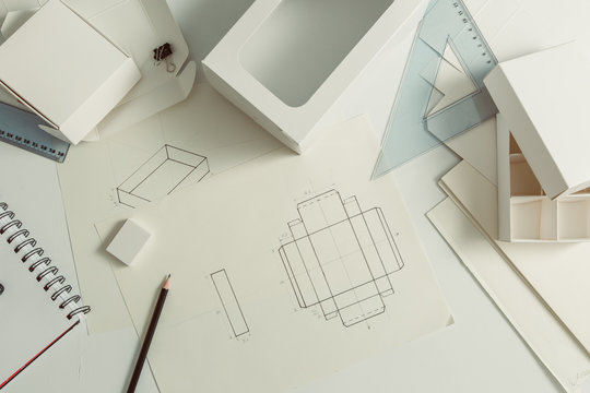 Workplace of the designer of cardboard packaging. Sketching paper boxes. 