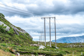 Summer day, clouds just above the tops of mountains in Northern Norway. The power line goes through the mountains
