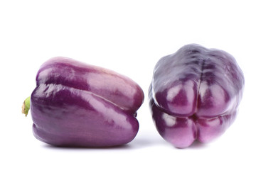 Two fresh purple bell peppers isolated on white background.