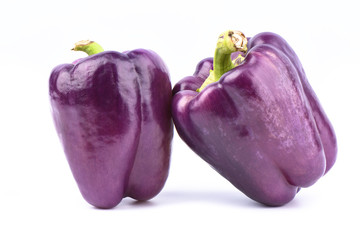 Two fresh purple bell peppers isolated on white background.