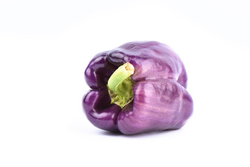 Fresh purple bell pepper isolated on white background.