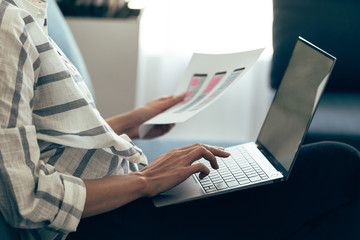 Young adult woman holding sketch with app interface in hand