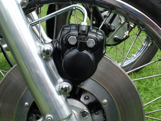 Obraz premium close up of a metal disk brake on the front wheel of an old motorcycle