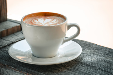 Cup of coffee on the table with copy space. Fresh cappuccino coffee drink on the windowsill.