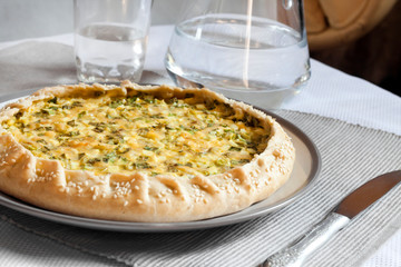 Tart with eggs and green onions on a plate