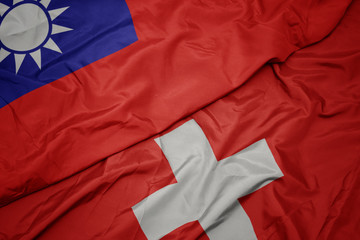 waving colorful flag of switzerland and national flag of taiwan.