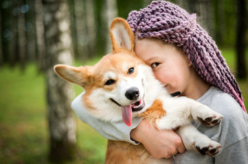 Beautiful girl walks with a puppy in a summer Park