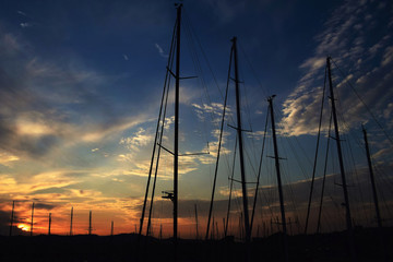 Atardecer entre nubes y mastiles, monta&ntilde;as y siluetas