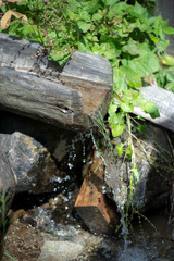 Wooden gutter for water. Mountain water supply to the mill. Spring with clear mountain water.
