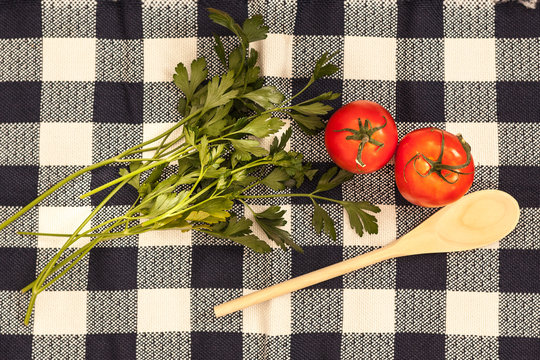 two fresh tomatoes parsley on tablecloth