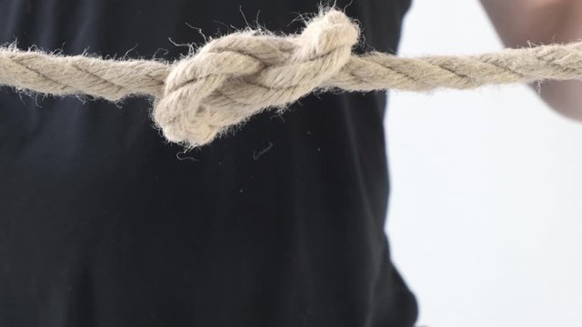 Person male hands tie a bowline knot in a piece of rope