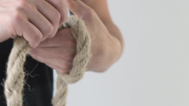 Man winding rope on his hand in black T-shirt
