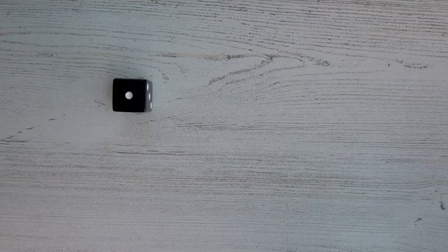 Slow motion, dice roll. 6 Sided die rolls a 6. 4k flat lay wooden background.