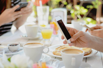 Friends using smartphone a coffee shop.