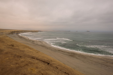 Dramatic coastline with intense colors in the desert of Paracas National Reserve, Peru