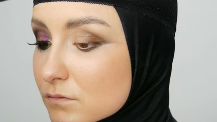 Professional stylist make-up artist makes eye makeup model. Face model with evening make-up close up view