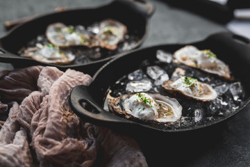 Raw oyster with mignonette sauce, celery & cream in cast iron on ice