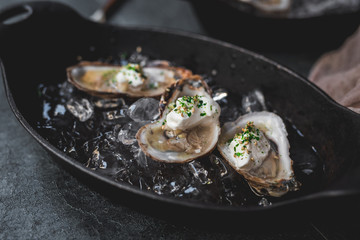 Raw oyster with mignonette sauce, celery & cream in cast iron on ice