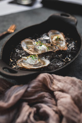 Raw oyster with mignonette sauce, celery & cream in cast iron on ice