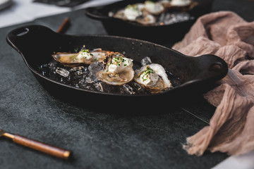 Raw oyster with mignonette sauce, celery & cream in cast iron on ice