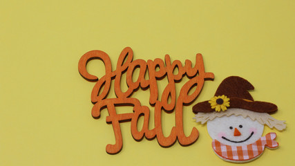 happy fall text, greeting card, fall image with happy scarecrow face laying flat on a festive yellow background. horizontal with copy space