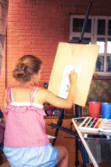 Fototapeta na wymiar Child girl painter painting on easel concept children inspiration art development