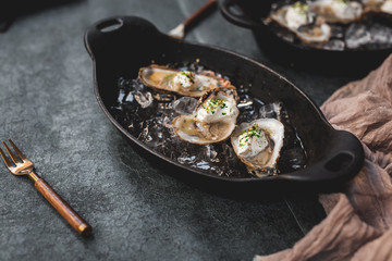Raw oyster with mignonette sauce, celery & cream in cast iron on ice