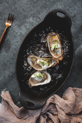 Raw oyster with mignonette sauce, celery & cream in cast iron on ice