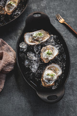 Raw oyster with mignonette sauce, celery & cream in cast iron on ice