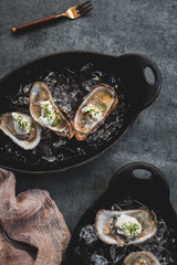 Raw oyster with mignonette sauce, celery & cream in cast iron on ice
