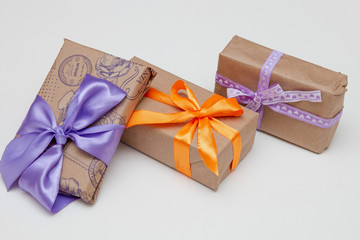 gifts in boxes on a white background place copy top view golden ribbon with a bow wrapped in brown paper purple ribbon braid