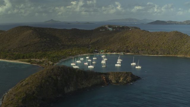 Aerial view of distant catamaran boats in bay near island / Salt Whistle Bay, Mayreau, St. Vincent and the Grenadines
