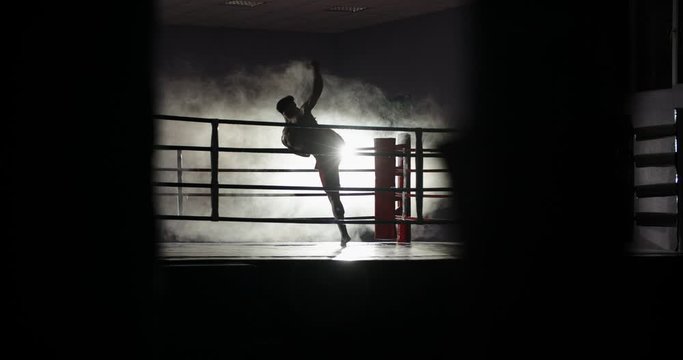 Dedicated athlete doing a shadow fight on boxing ring, practicing muay thai martial art, preparing for a fight - sports, martial arts concept 4k footage