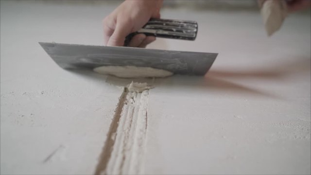 Hands Plasterer at work. Application of the plaster on the wall. textured plaster. Plastering the wall.