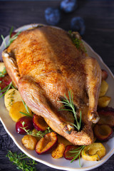 Whole duck with potatoes, plums and herbs