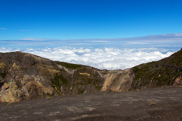 A blanket of clouds, on a clear day, reaches the top of the Irazu volcano in Costa Rica