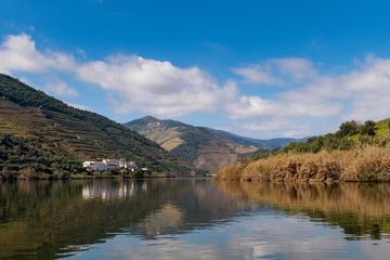 Fototapeta na wymiar Scenic view of the Pinhao village with terraced vineyards and the Douro River and the Douro Valley, in Portugal; Concept for travel in Portugal and most beautiful places in Portugal