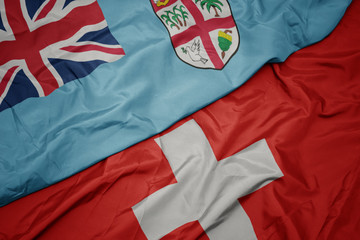 Fototapeta premium waving colorful flag of switzerland and national flag of Fiji .