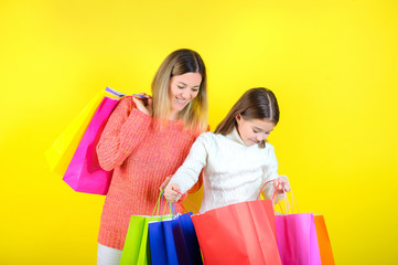 mom and daughter hold shopping bags, family makes purchases