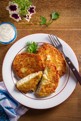 Potato Pancakes Stuffed With Cottage Cheese. Homemade vegetable fritters on white plate, wooden table