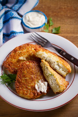 Potato Pancakes Stuffed With Cottage Cheese. Homemade vegetable fritters on white plate, wooden table