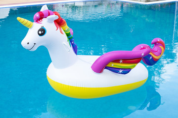 Inflatable unicorn in pool. Pool party, summer holidays, beach vacation. Fantasy swim ring for summer pool trip. Copyplace, place for text © Marharyta